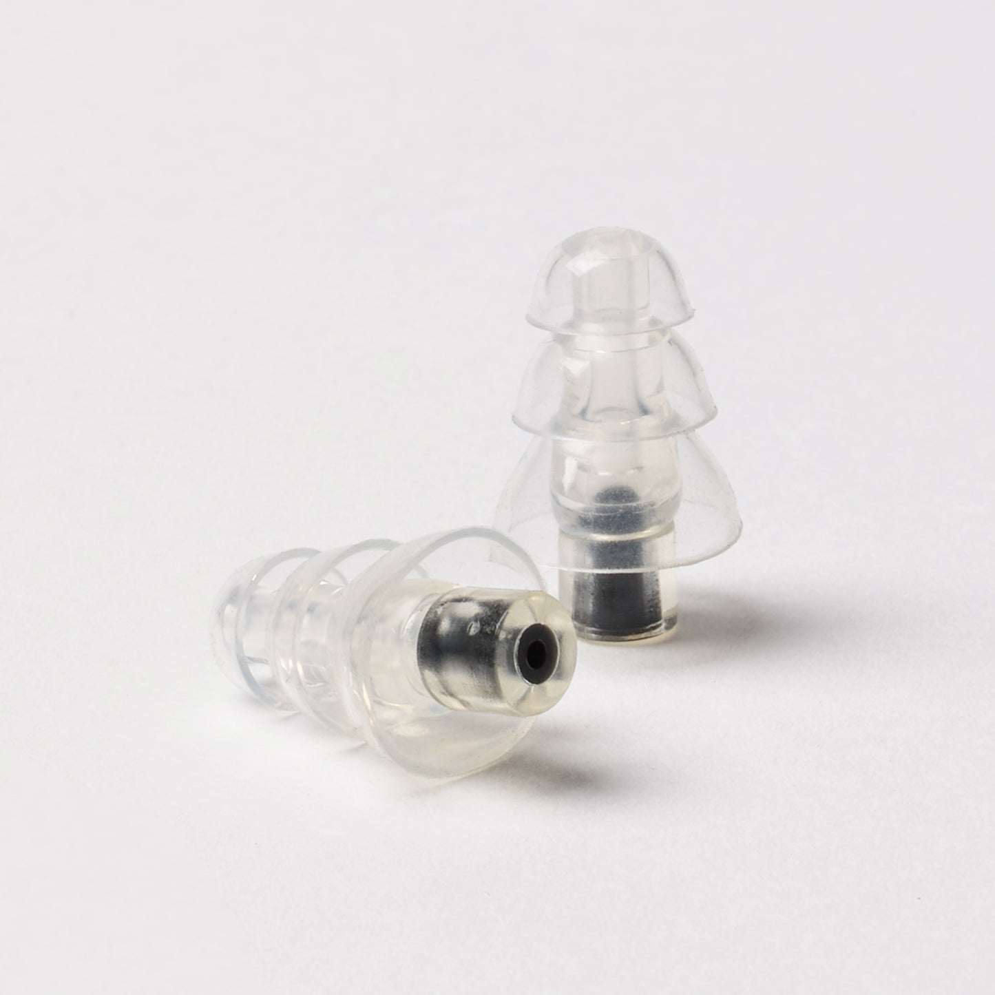 Close-up of clear silicone triple-flange earplugs designed for high-fidelity sound and noise reduction.